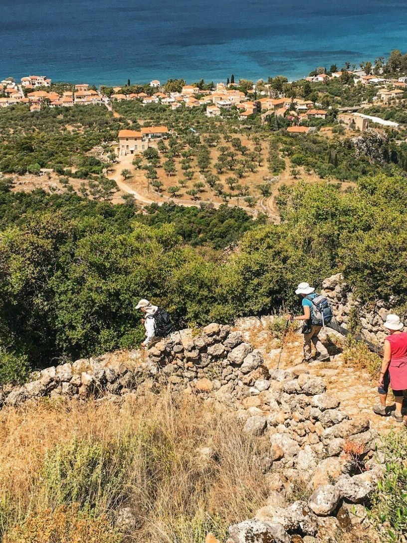 Randonneurs sur un sentier côtier au-dessus d'une baie turquoise - Péloponnèse - Grèce