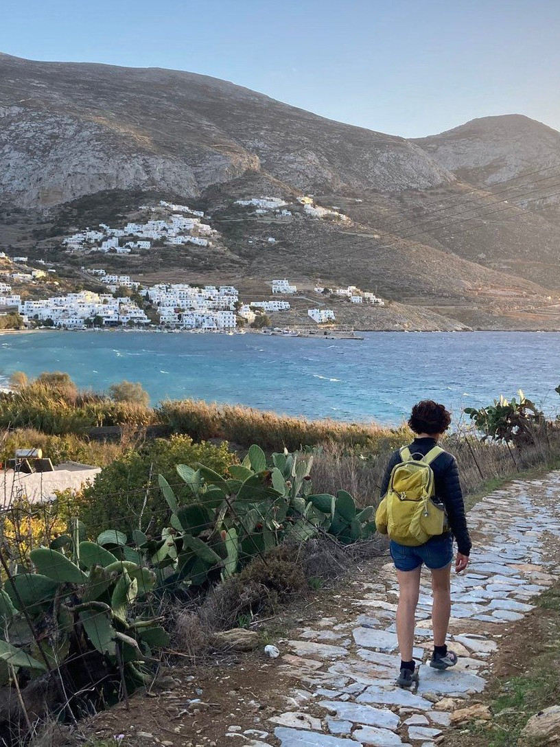 Randonneuse sur un chemin pavé au-dessus de la baie - Amorgos, Cyclades - Grèce © Willy Valette